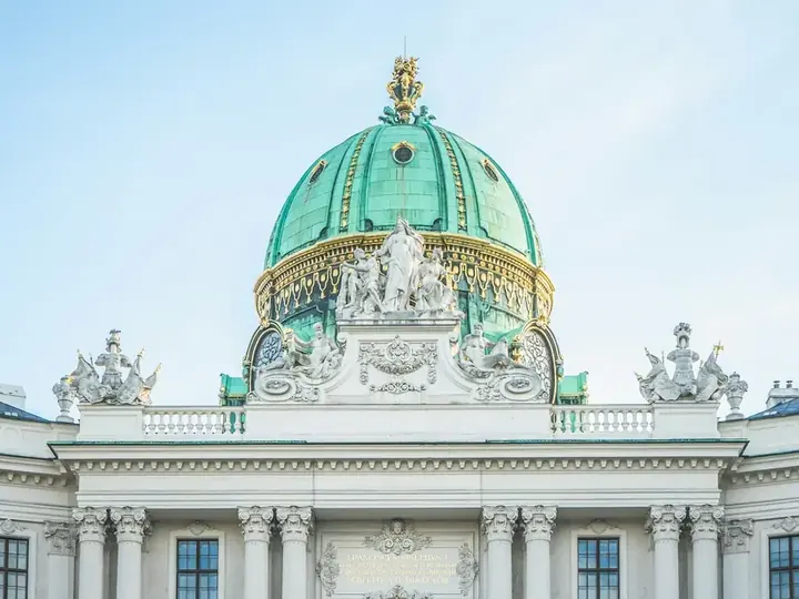 The green dome of the Hofburg palace in Vienna against a clear sky
